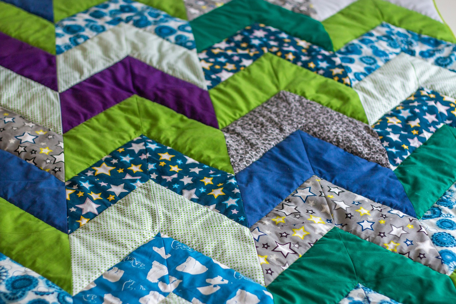 Close-up of a warm-toned quilt on a bed